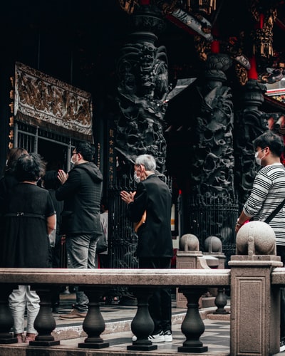 白天人们站在灰色的水泥栅栏上
